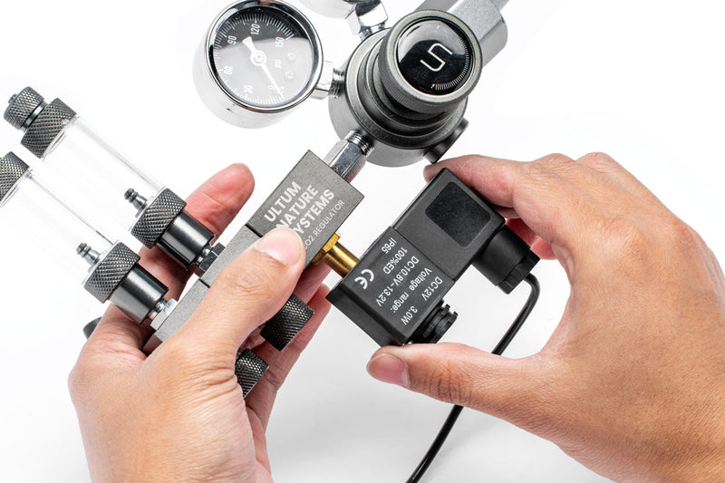 UNSCO2 CO2 regulator solenoid replacement accessory, showing the compact brass valve and electrical connection for gas control.