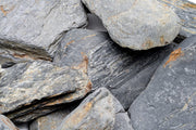 Dark blue slate stone from UNSHARDSCAPE with a smooth, natural surface and rich color, ideal for landscaping or decorative use.
