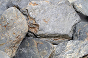 Dark blue slate stone from UNSHARDSCAPE, showing textured natural surface suitable for landscaping and decorative use.