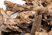 Natural driftwood piece labeled Madra Wood by UNSHARDSCAPE, showcasing its textured, weathered wood surface on a neutral background.