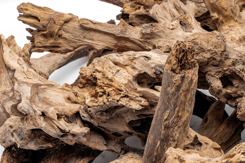Natural driftwood piece labeled Madra Wood by UNSHARDSCAPE, showcasing its textured, weathered wood surface on a neutral background.