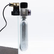 Dymax CO2 disposable cartridge holder accessory with black plastic body and metal fittings for easy CO2 bottle attachment.