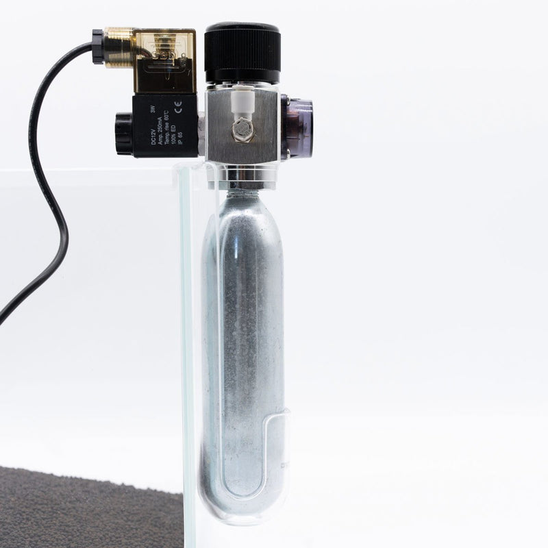 Dymax CO2 disposable cartridge holder accessory with black plastic body and metal fittings for easy CO2 bottle attachment.