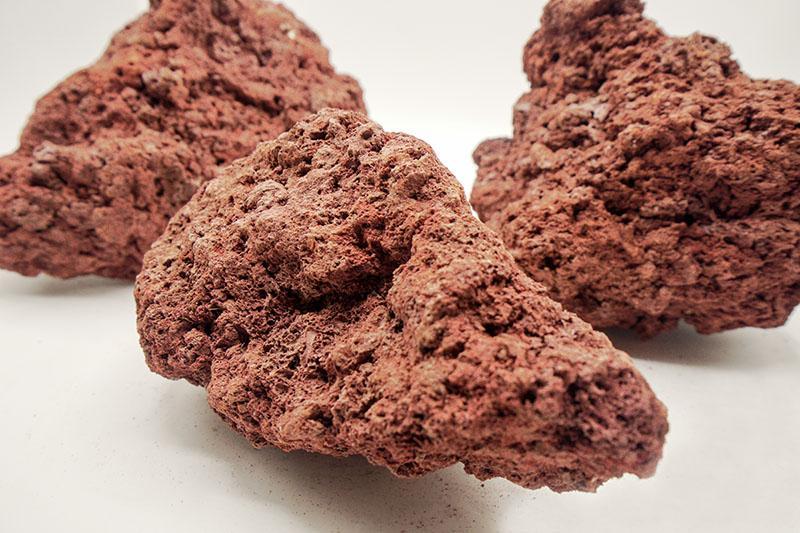 Red Lava Rock stone by SB showing textured, porous red volcanic rock with natural surface details.
